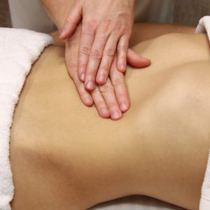 Women's abdomen being massaged by two hands